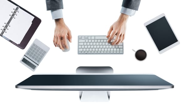 Executive businessman working on his computer at office desk, white background, hands top view