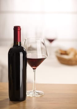 Red wine glass and bottle still life at restaurant.