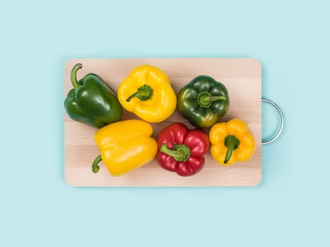 Fresh bell peppers on a wooden chopping board: healthy eating and food preparation