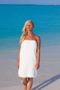 Blonde girl walks by the sea