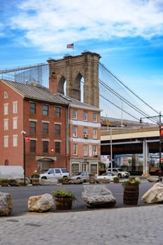 Brooklyn Bridge, New York, United States - June 08, 2015: People walk and while other tourists observe, from the bridge, the Manhattan skyline.