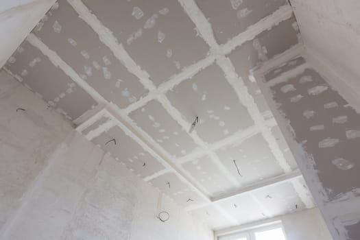 The ceiling of the room, covered with plasterboard sheets, and putty stitches