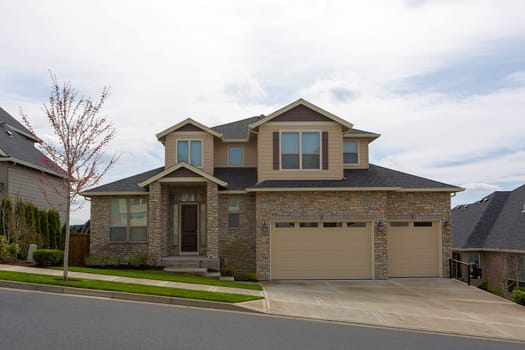 New custom built upscale house in Happy Valley Oregon suburban neighborhood with cultured stone exterior and three car garage
