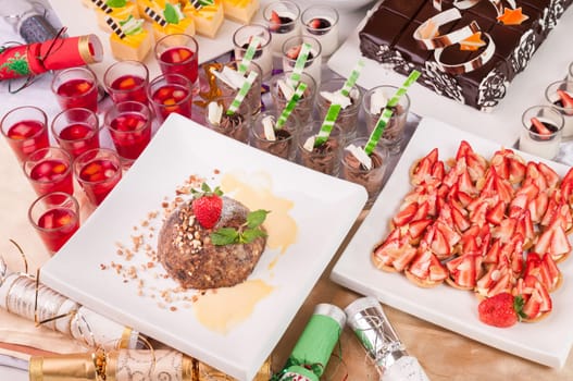 An array of Christmas desserts with bon bons on a table top view