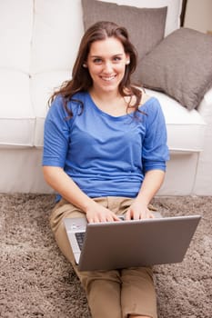 this beautiful self confident girl uses her notebook in relax in her living room