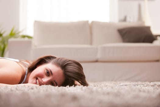 happy girl on the carpet in her living room laughing or smiling