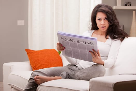 woman reading news in her living room until time to work comes