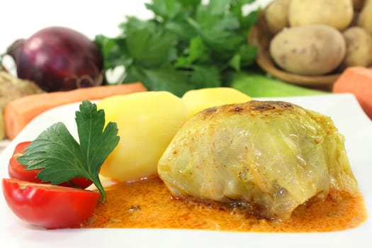 a plate of cabbage roulade and potatoes
