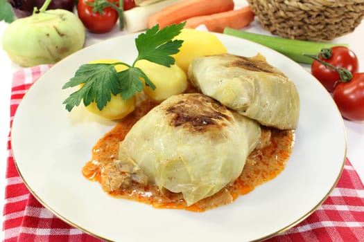 a plate of cabbage roulade and potatoes