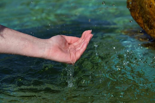 Woman's hand on the water