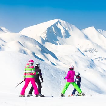 Family on winter ski vacations in ski slopes in Alps, Vogel, Slovenia, Europe.