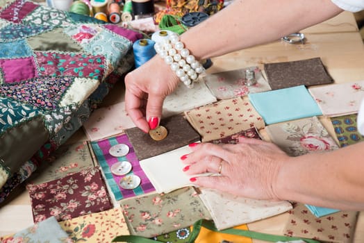 Close up of woman's hand sewing patchwork