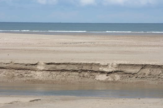 Waves with white crests inundate the sandy beach