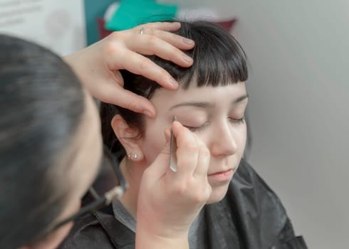 Permanent makeup. Verification of proportions. Cosmetologist applying permanent make up on eyebrows- eyebrow tattoo