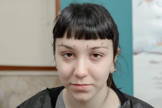 Permanent makeup. Verification of proportions. Cosmetologist applying permanent make up on eyebrows- eyebrow tattoo