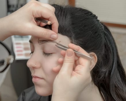 Permanent makeup. Verification of proportions. Cosmetologist applying permanent make up on eyebrows- eyebrow tattoo