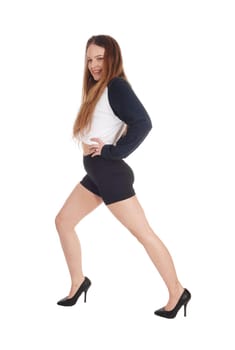 A young beautiful woman in black shorts and high heels standing.isolated for white background.