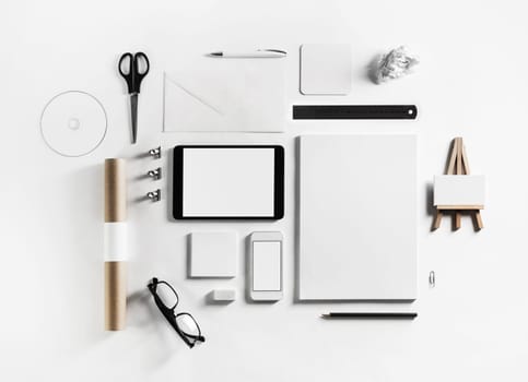 Blank corporate stationery and gadgets set on white paper background. Top view. Flat lay.