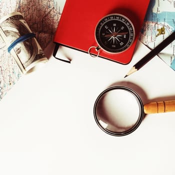 Travel stationery set. Paper, magnifier, map, compass, notebook, money and pencil. Tourism concept. Vintage toned image. Top view. Flat lay.