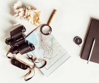 Making a travel plan. Tourist devices on white paper background. Vintage toned image. Top view. Flat lay.