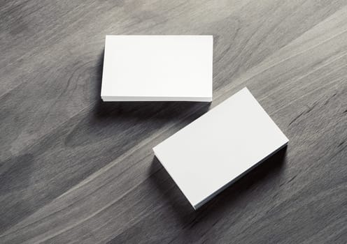 Two horizontal blank business cards stacks on vintage wooden background. Mockup for ID.