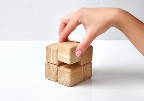 Stack of wooden blocks on white table isolated business concept.Part of whole.Financial growth success.Building process.