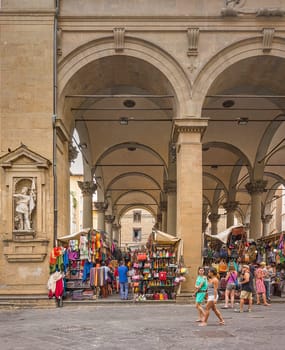 Florence, Italy, June 2015: tourists and Florentines walking and shopping in the historic Mercato del Porcellino (pig market) in the center of Florence with Tuscan leather goods