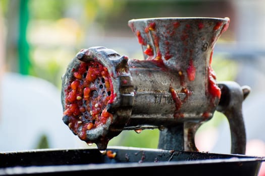 Hand-powered mincing machine used for grinding paprika. Meat or paprika grinder for preparing traditional slavic dishes