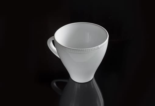 White empty cup on a dark background for a drink