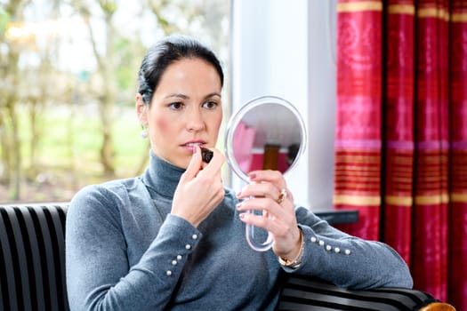 young dark haired woman at home applying make up