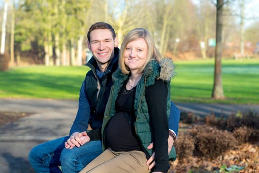 young pregnant woman with her husband in the park