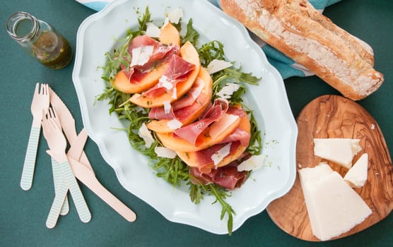 Colorful summer salad with rucula,sugar melon and Serrano ham