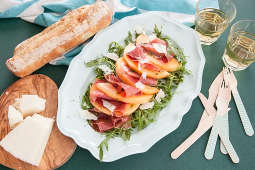 Colorful summer salad with rucula,sugar melon and Serrano ham