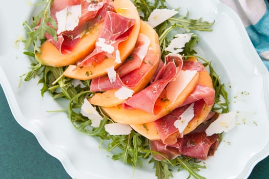Colorful summer salad with rucula,sugar melon and Serrano ham
