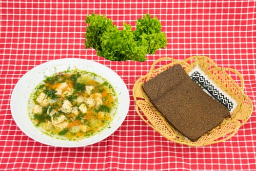 Healthy Fish soup salmon , Fresh green salad and whole grain bread in basket on red white checkered tablecloth. Health concept. Top view.