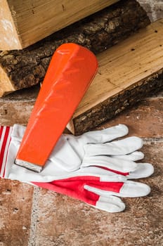 Saw, mittens and firewood, close-up