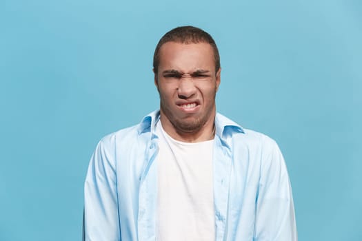 Ew. It's so gross. Young man with disgusted expression repulsing something. Disgust concept. Young emotional afro man. Human emotions, facial expression concept. Studio. Isolated on trendy color
