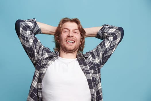 Happy business man standing, smiling isolated on trendy blue studio background. Beautiful male half-length portrait. Young satisfy man. Human emotions, facial expression concept. Front view.