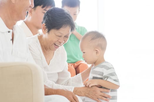 Happy Asian family relaxing at home, candid moment of multi generations people indoor lifestyle.