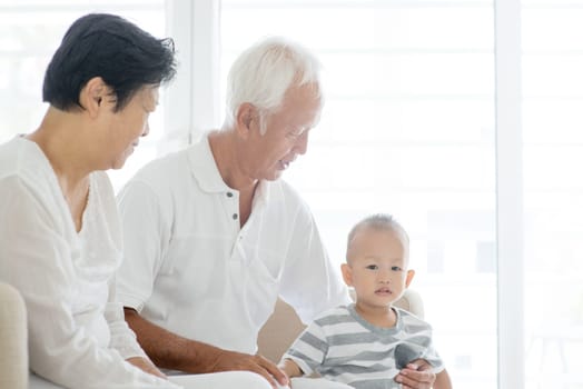 Portrait of Asian grandparents and grandchild at home, family indoor lifestyle.