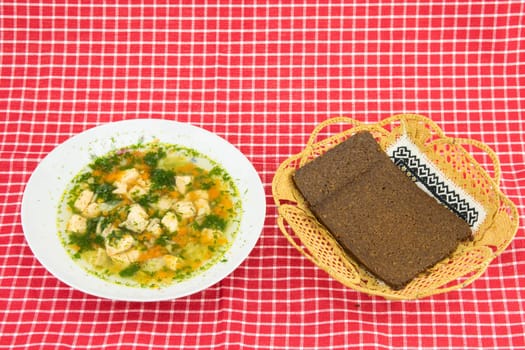 Healthy Fish soup salmon and whole grain bread in basket on red white checkered tablecloth. Health concept. Top view.