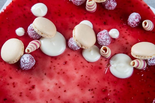 Decoration with raspberries, chocolates and biscuits on a cake