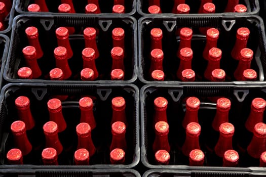 A group of red bottles in beer crates