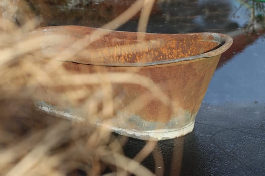 Rusty old bathtub on frozen lake.