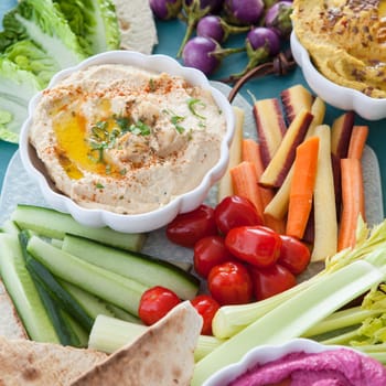 Different varieties of hummus with fresh vegetables