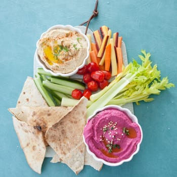 Different varieties of hummus with fresh vegetables