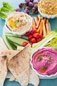 Different varieties of hummus with fresh vegetables