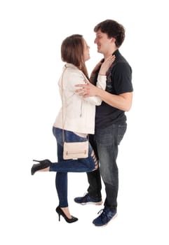 A beautiful young couple standing front to front and smiling at each.other, in jeans, isolated for white background.