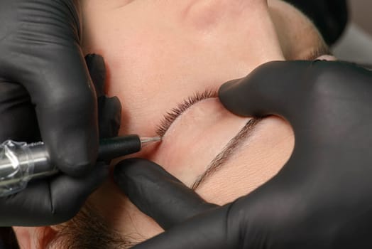 Permanent makeup. Permanent tattooing of eyebrows. Cosmetologist applying permanent make up on eyebrows- eyebrow tattoo