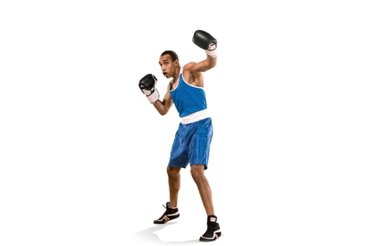 Sporty man during boxing exercises. Photo of boxer on isolated on white background. Strength, attack and motion concept. Fit african american model in movement. Afro muscular athlete in sport uniform